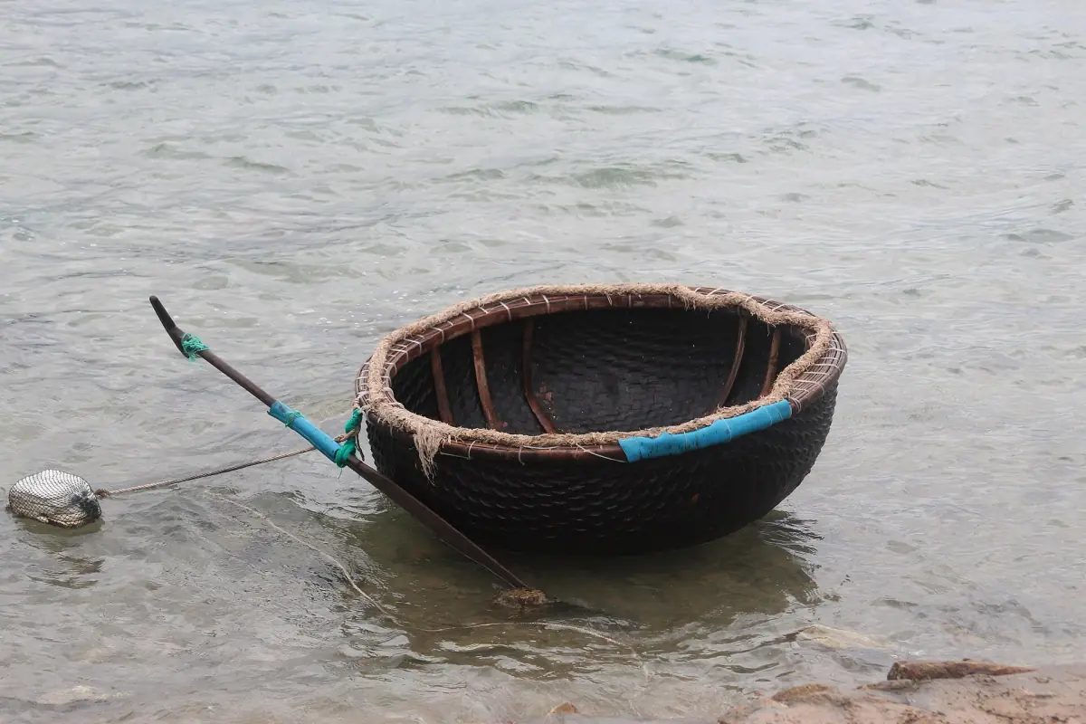A single basket boat floating close to shore